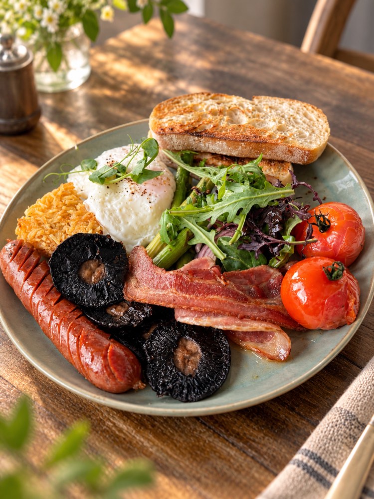 Big breakfast plate: chorizo, mushrooms, bacon, asparagus, poached egg, potato hash, tomatoes, greens and ciabatta