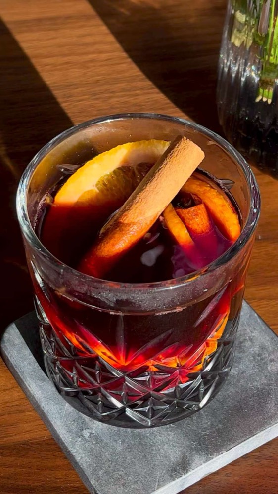 Mulled wine in a cut-glass tumbler with orange and a cinnamon stick